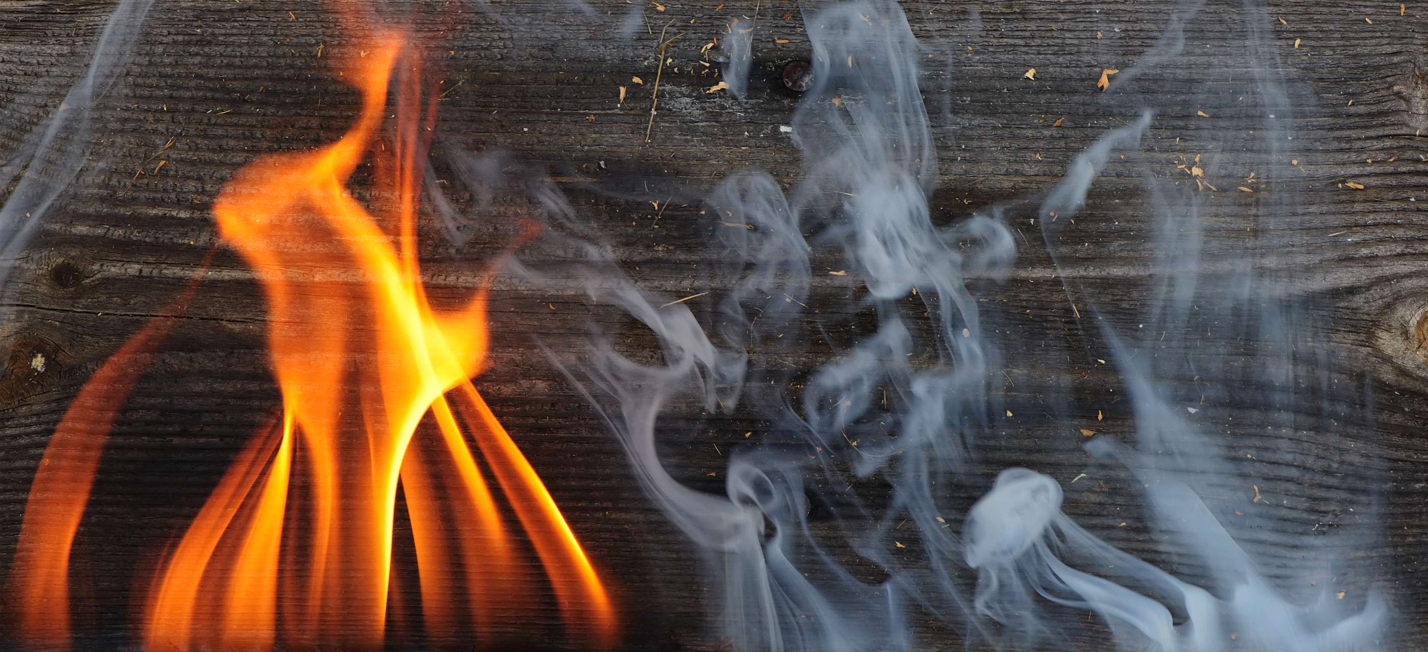 A piece of wood catching on fire with smoke