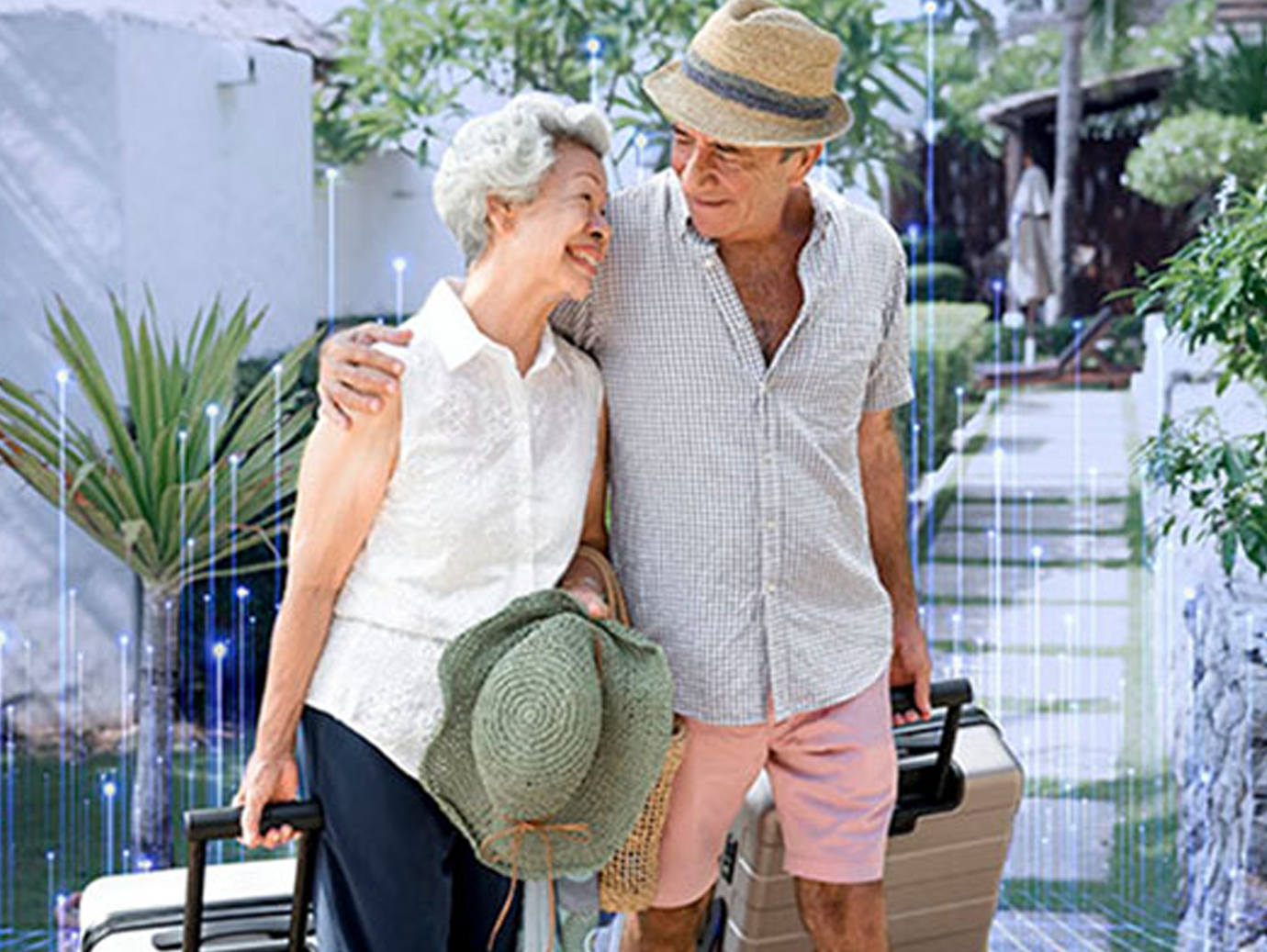 An elderly couple smiling and carrying luggage 