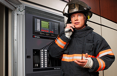 Firefighter using a fire control panel