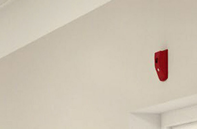 A red notification appliance installed on a wall