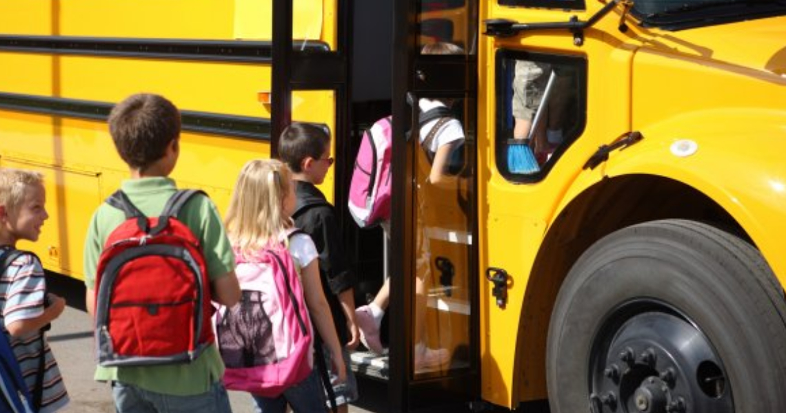 Young students boarding a school bus