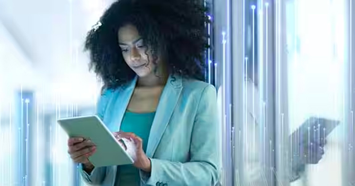 woman using a tablet by leaning on  a glass door