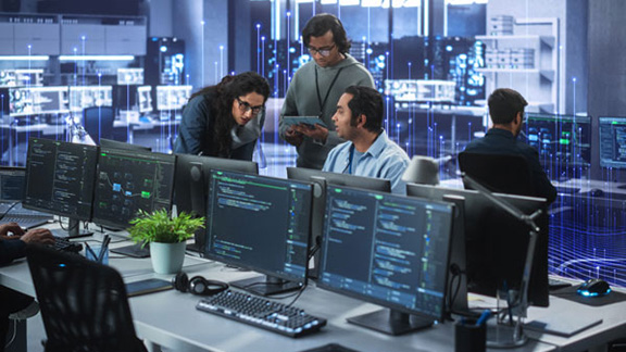 A group of colleagues working on desktops in an office