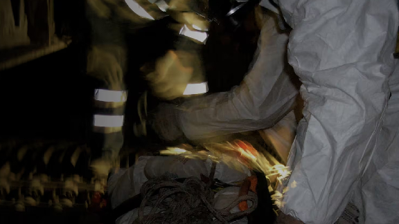 Maintenance workers kneeling in front of safety equipment