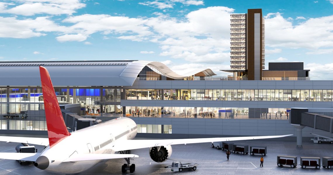An airplane parked at an airport terminal with a tall building in the background