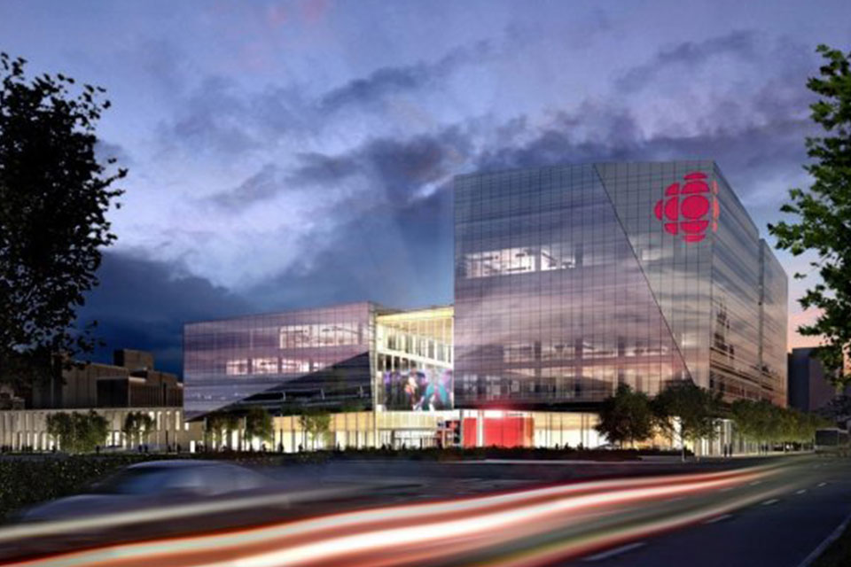 A glass building at dusk with motion blur cars