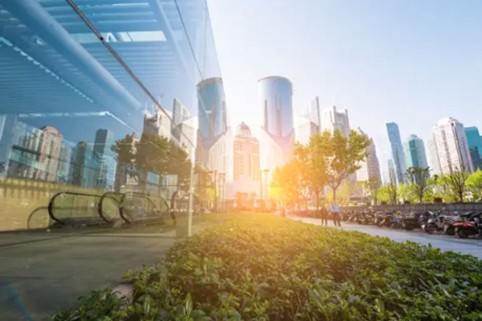 Glass buildings with the sun shining between two buildings
