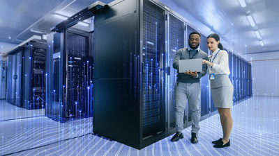 A man and a woman standing in a hub room and looking at a laptop